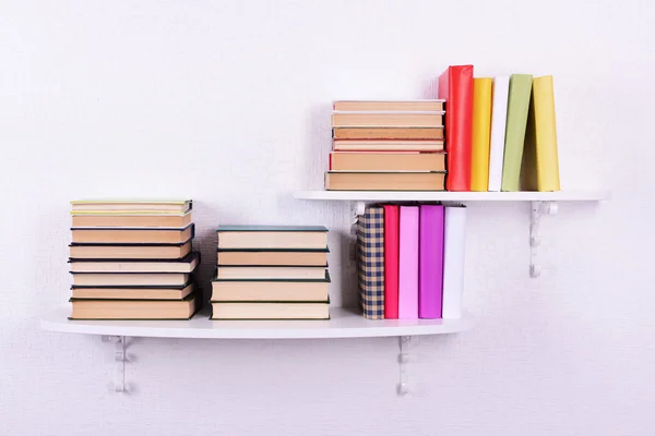 Books on shelves on white wall background