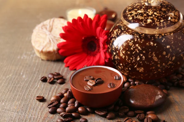Composition of spa treatment, flowers and coffee beans on wooden background