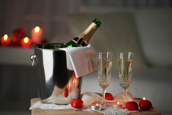 Champagne glasses and rose petals for celebrating Valentines Day, on dark background