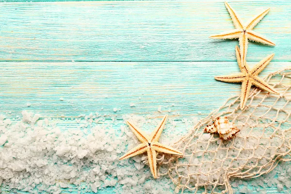Sea stars on sea salt on wooden background