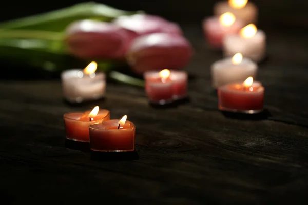 Romantic atmosphere with candle lights and flowers on dark background