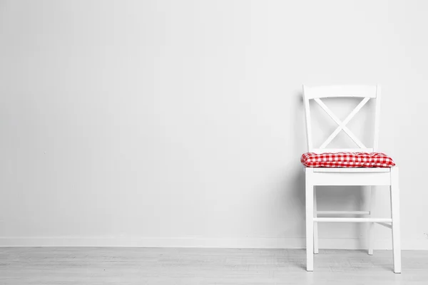 Modern chair with pillow on white wall background