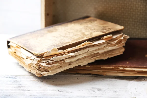 Old wooden suitcase with old books on wooden background