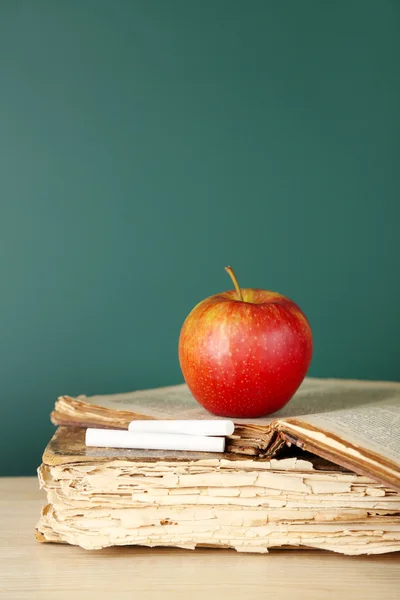Old books, apple and chalk
