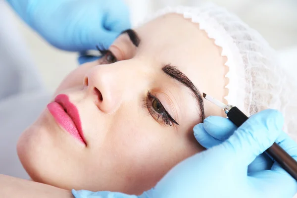 Cosmetologist applying permanent make up