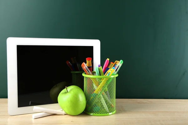 Digital tablet, colorful pens and apple