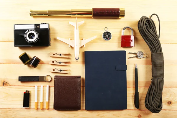 Travel gear on wooden table, top view