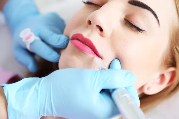 Cosmetologist applying permanent make