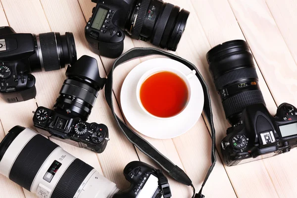 Modern cameras on wooden table