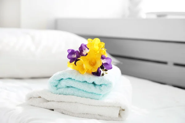 Colorful beautiful freesias on fresh towels in hotel, close up