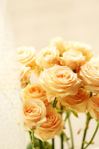 Bouquet of beautiful fresh roses on curtains background