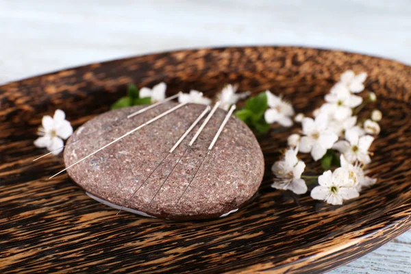 Acupuncture needles on wooden plate