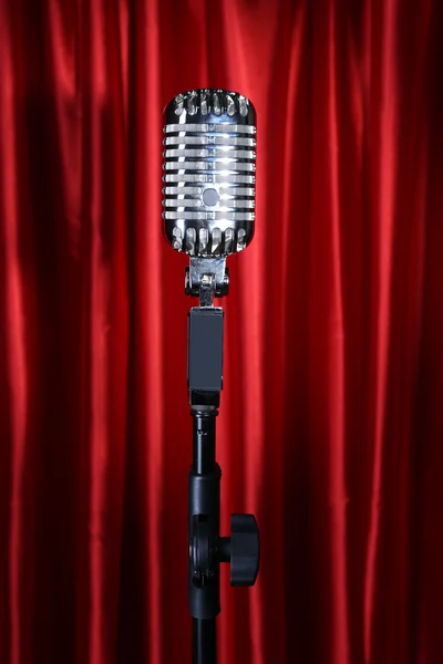 Retro silver microphone on red fabric background