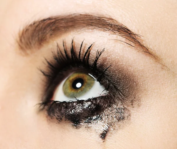 Eye of young woman with tear drop close up