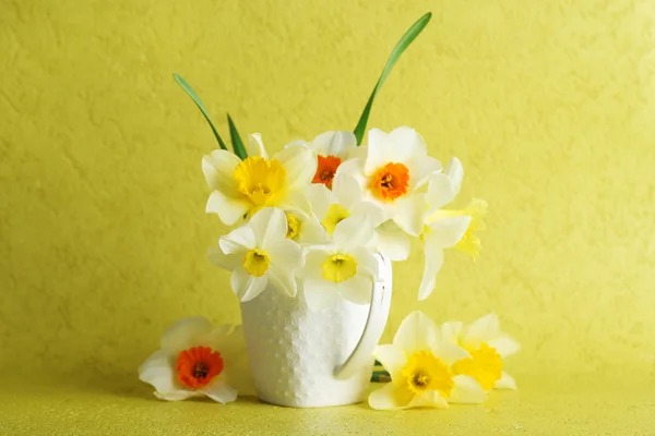 Fresh narcissus flowers on yellow wallpaper background