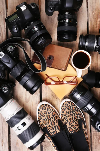 Still life with modern cameras on wooden table, top view