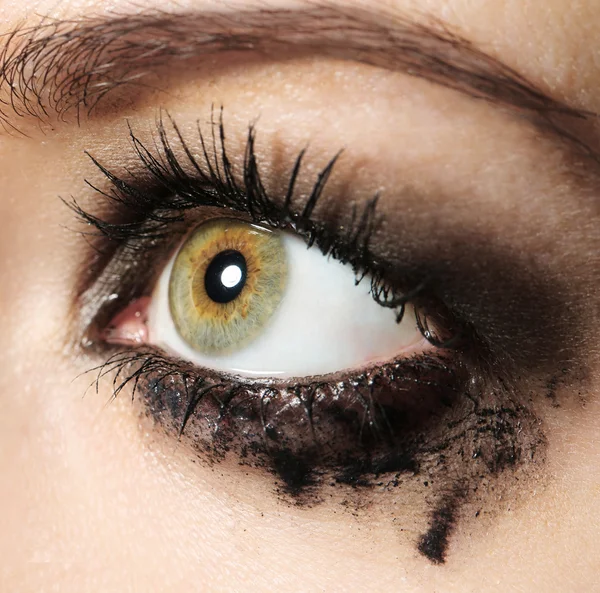 Eye of young woman with tear drop close up