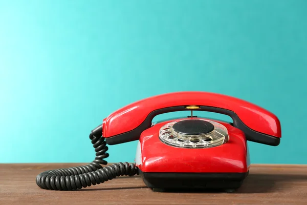 Retro red telephone on table on green background
