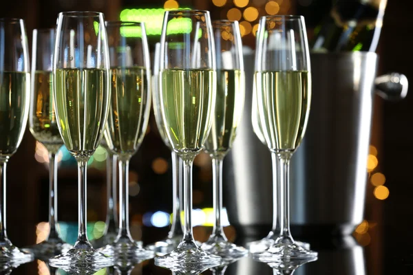 Glasses of champagne on bar background