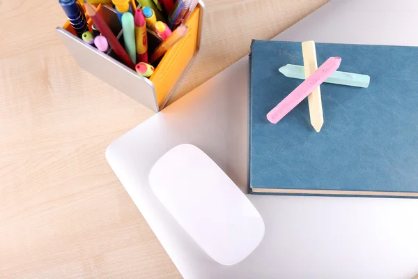 Books, computer mouse and pieces of chalk on wooden table background