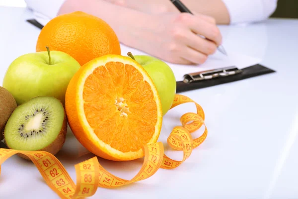 Nutritionist doctor writing diet plan in office