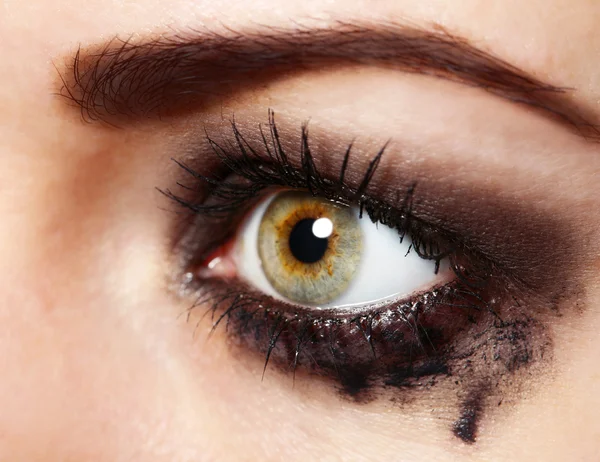 Eye of young woman with tear drop close up