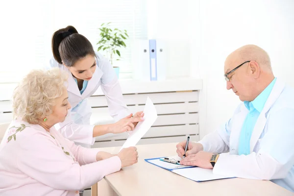 Happy doctors and patient in hospital clinic