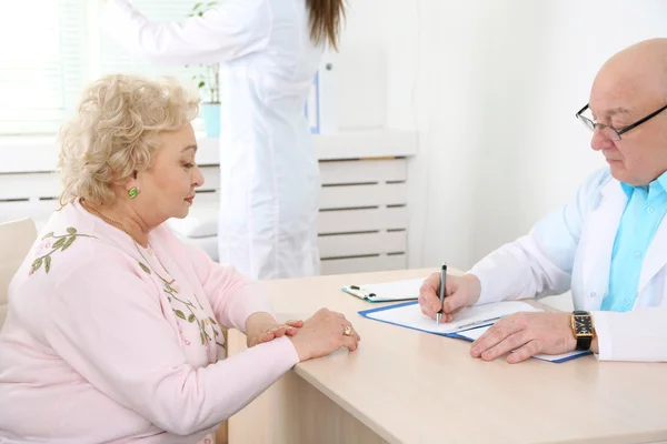 Happy doctors and patients in hospital clinic