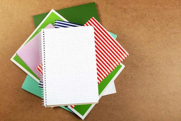 Notebook on top of pile of books and magazines