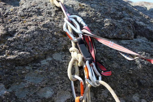 Rock climbing rope with hooks on  rock, close-up