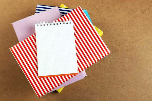 Notebook on top of pile of books and magazines