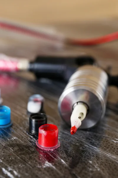 Tattoo Supplies - machine and inks on table close up