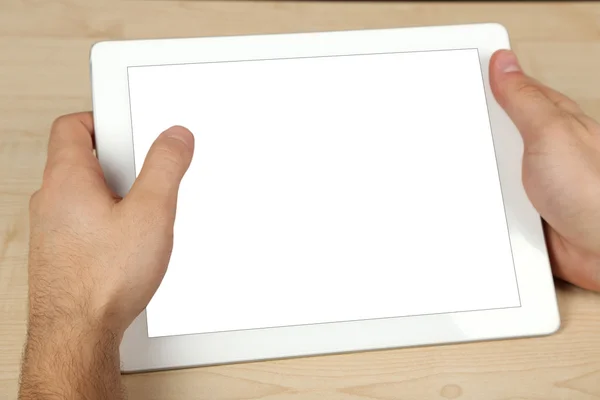 Human using tablet PC on wooden table background