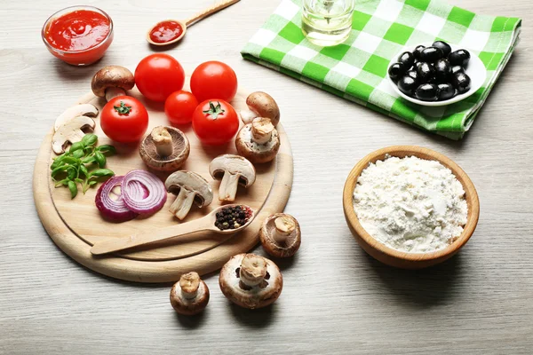 Ingredients for cooking pizza on wooden table background