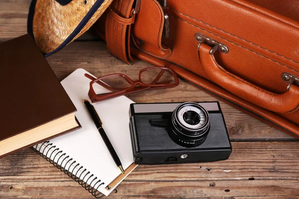 Packing suitcase for trip on wooden background