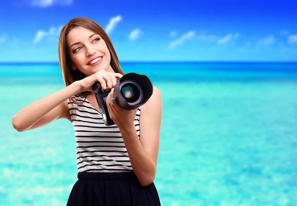 Young female photographer taking photos on nature background