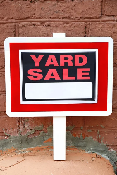 Yard Sale sign on brick wall