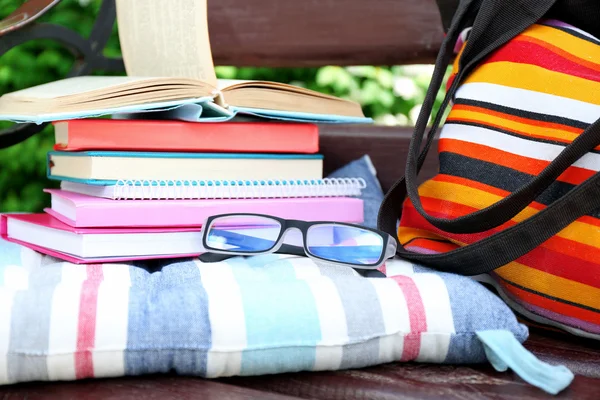Books, glasses and bag on bench