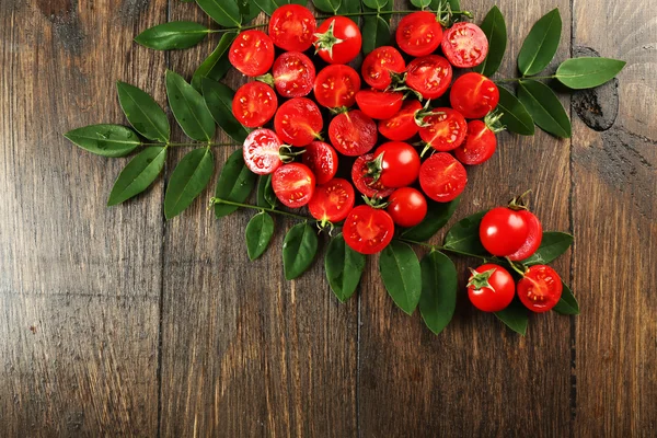 Cherry tomatoes arranged in heart shape with green leaves