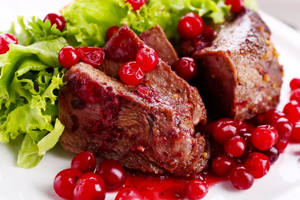 Tasty roasted meat with cranberry sauce