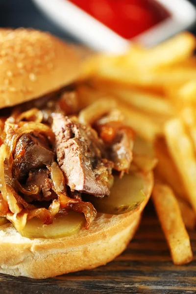 Tasty burger and french fries on wooden table background , close-up Unhealthy food concept