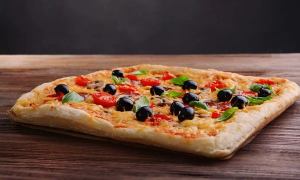 Delicious homemade pizza on table on black background