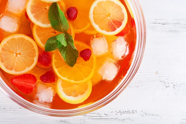 Fruity punch in glass bowl on wooden table, top view