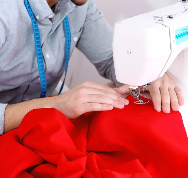 Man direct fabric in sewing machine