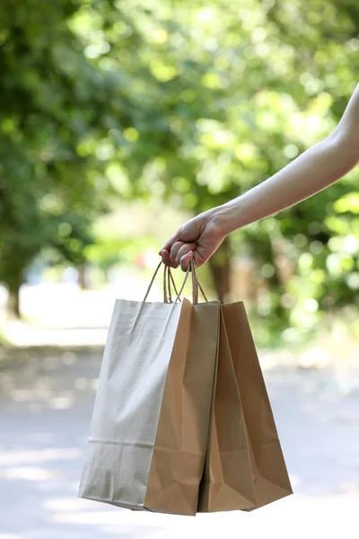 Female hand holding shopping bags outdoors