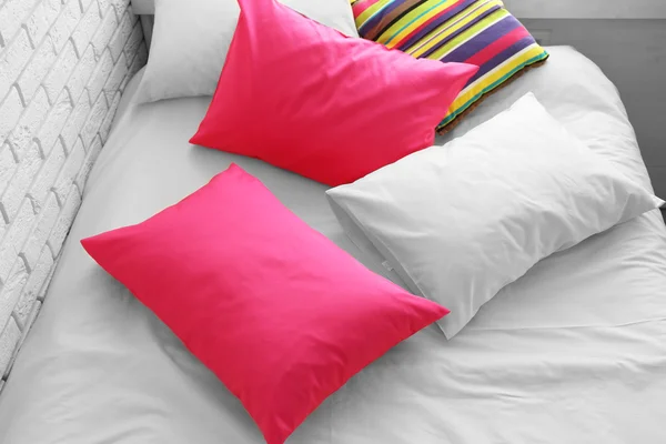 Comfortable bed with colorful pillows in bedroom
