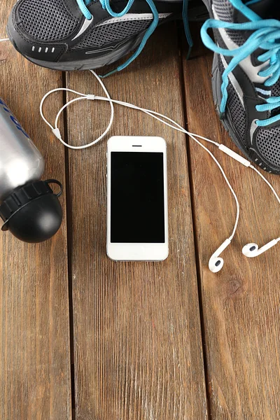 Sneakers and earphones on wooden table