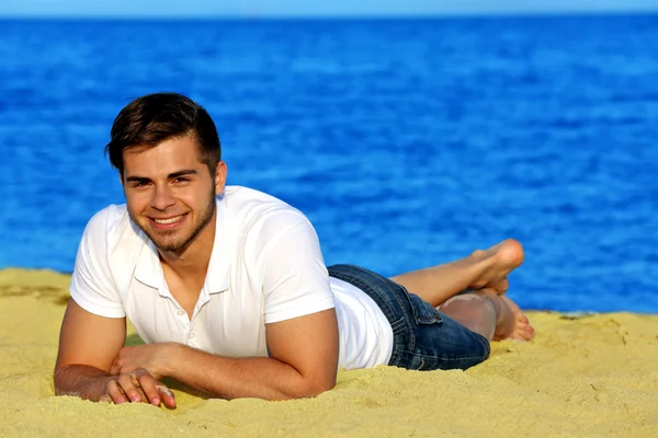 Pretty guy lying on beach