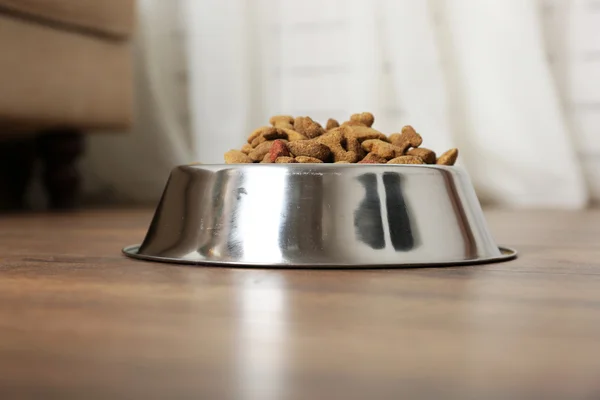 Dog food in bowl on floor at home