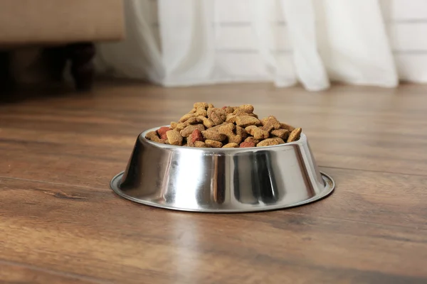 Dog food in bowl on floor at home